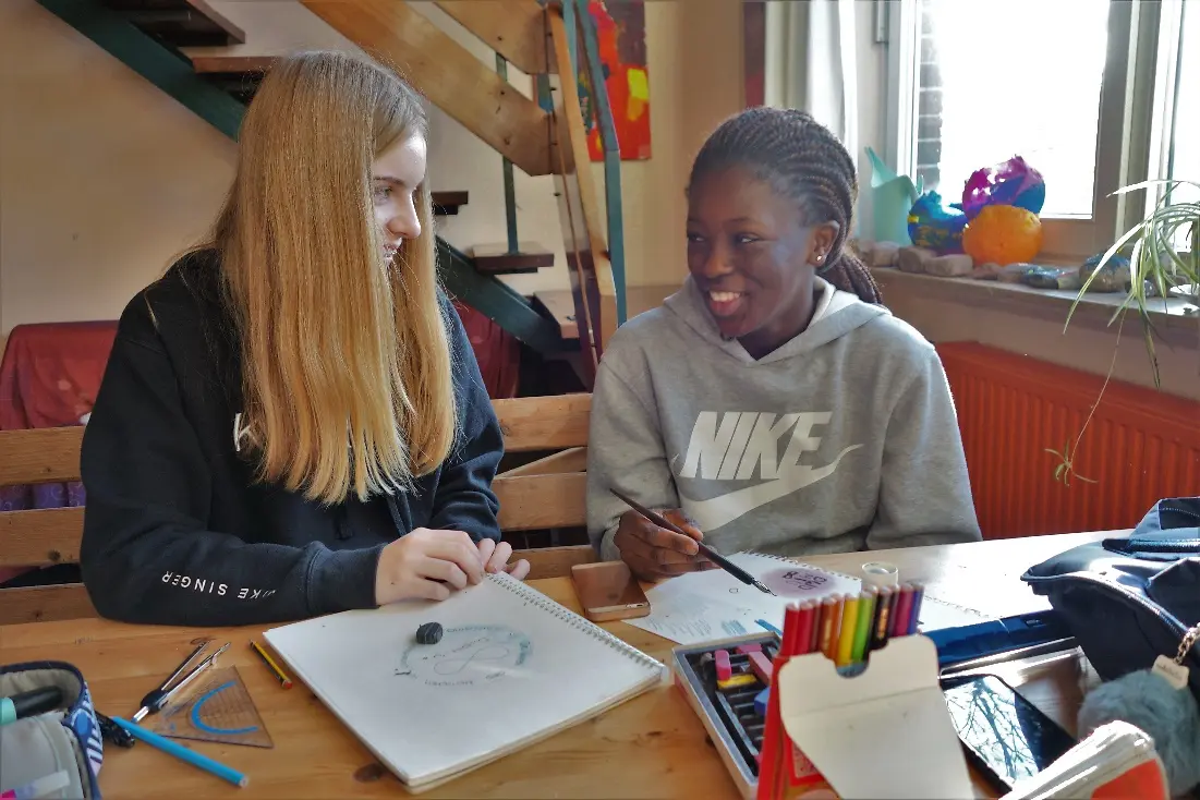 Zwei Mädchen sitzen an einem Schreibtisch