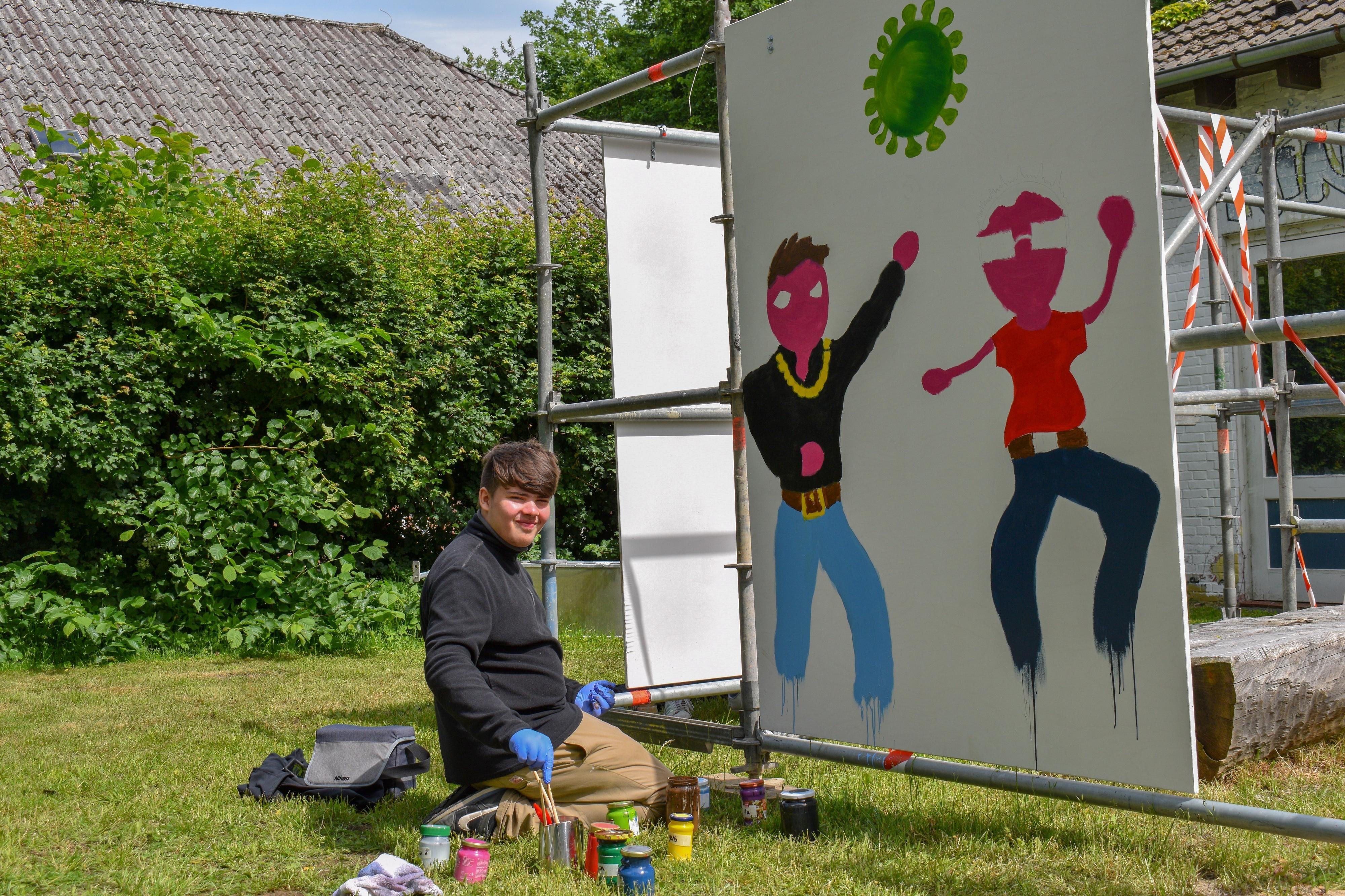 Ein junger Mann präsentiert stolz sein Kunstwerk