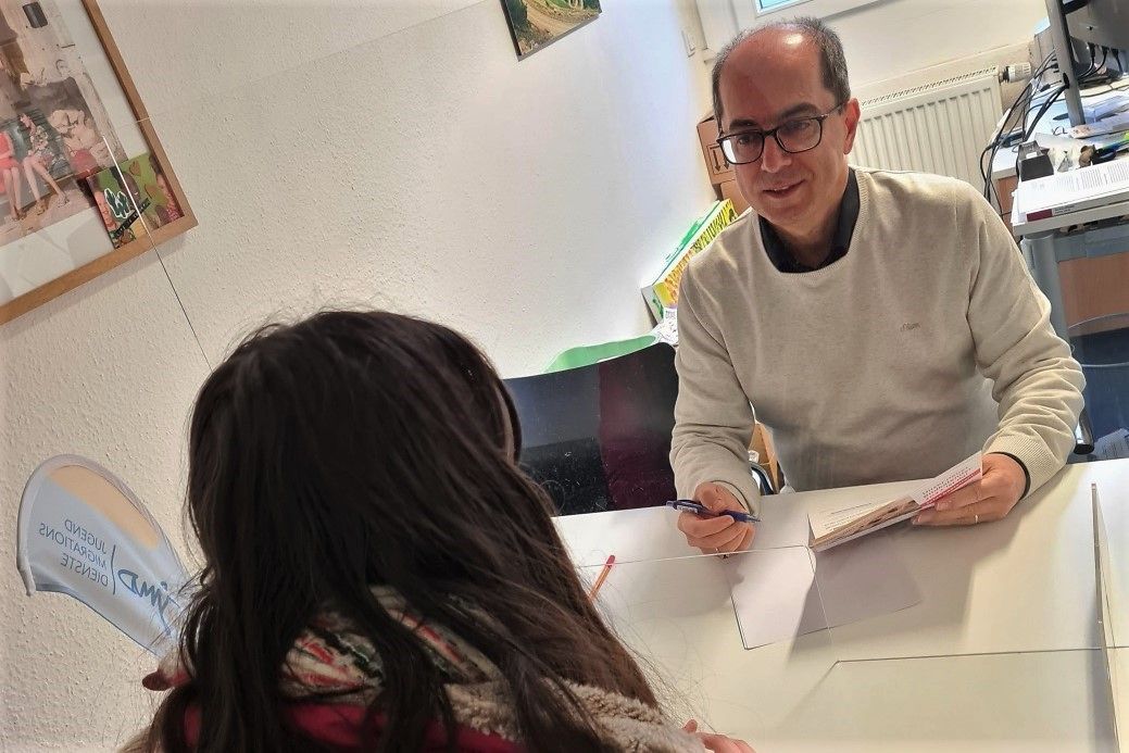 Ein Mann und eine Frau an einem Tisch sitzend im Gespräch. 