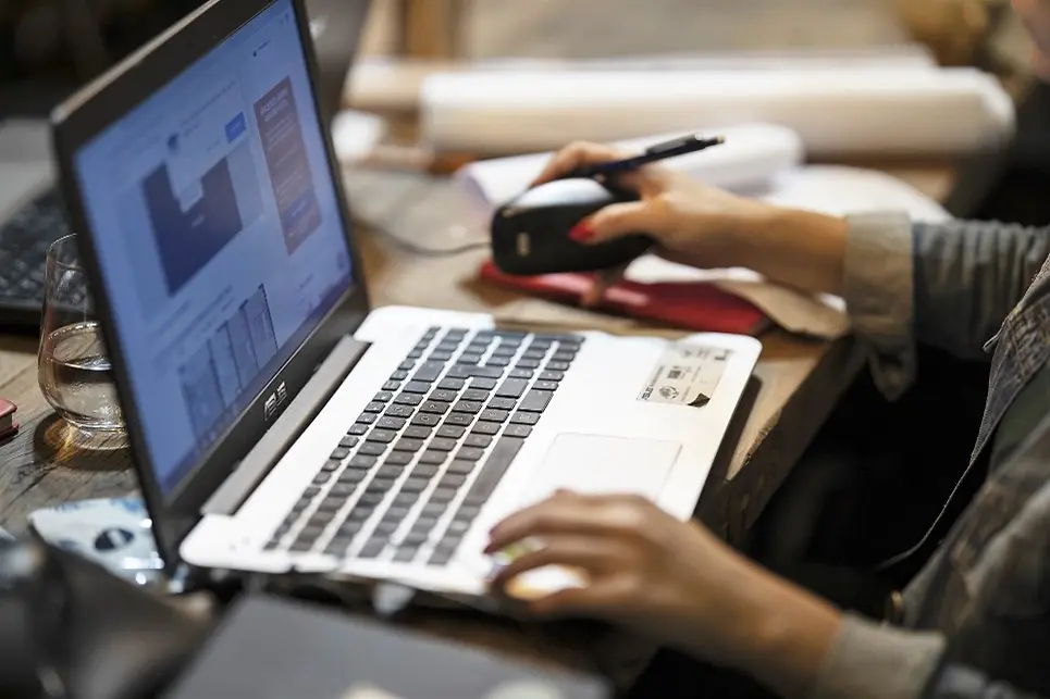 Laptop an dem jemand schreibt.