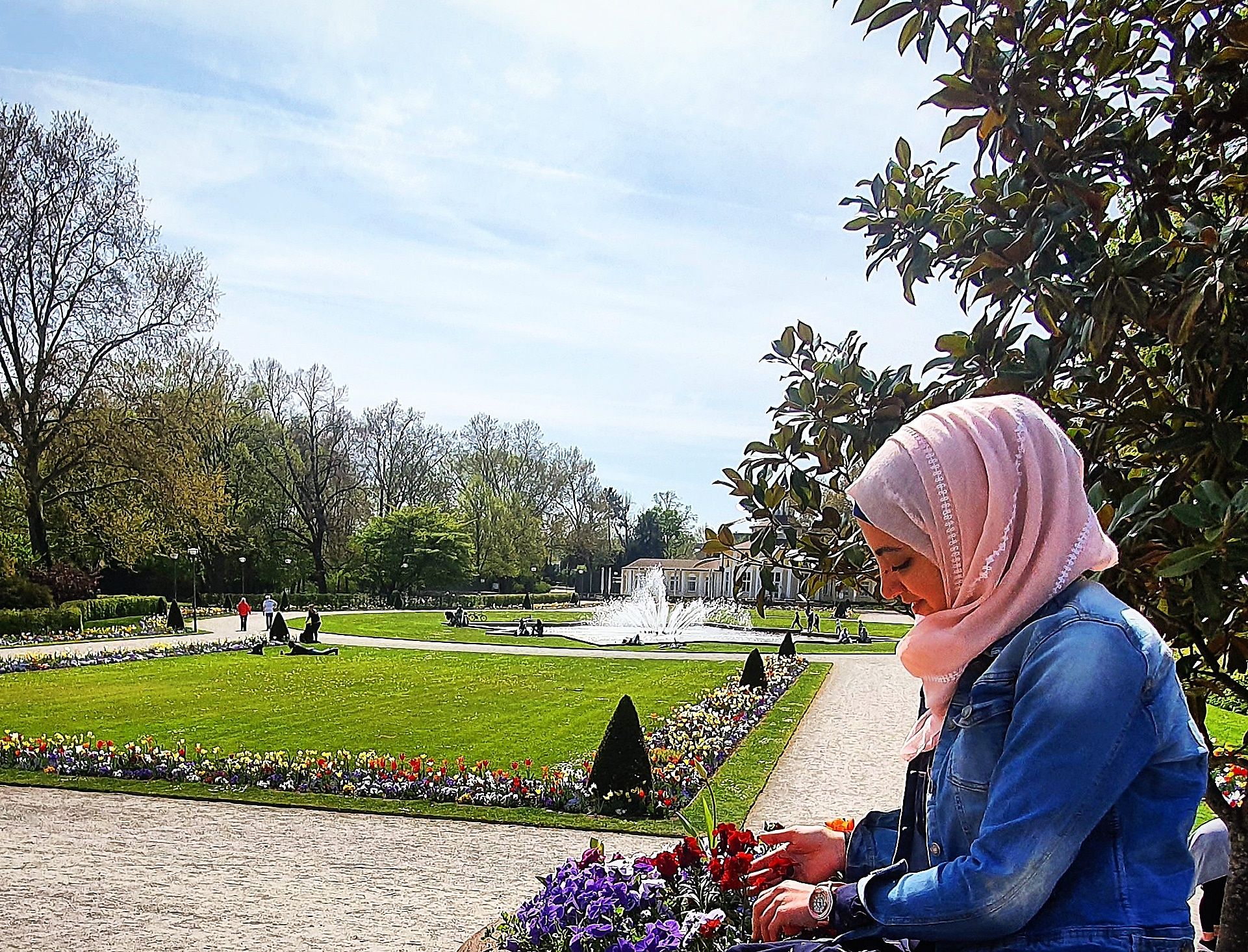 Randa betrachtet in einem Park die Blumen.