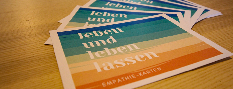 Mehrere Karten mit der Aufschrift Leben und leben lassen liegen auf einem Tisch