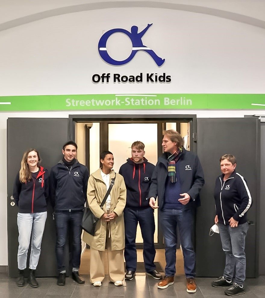 Sechs Menschen stehen vor dem Logo der Off Road Kids der Streetwork-Station Berlin