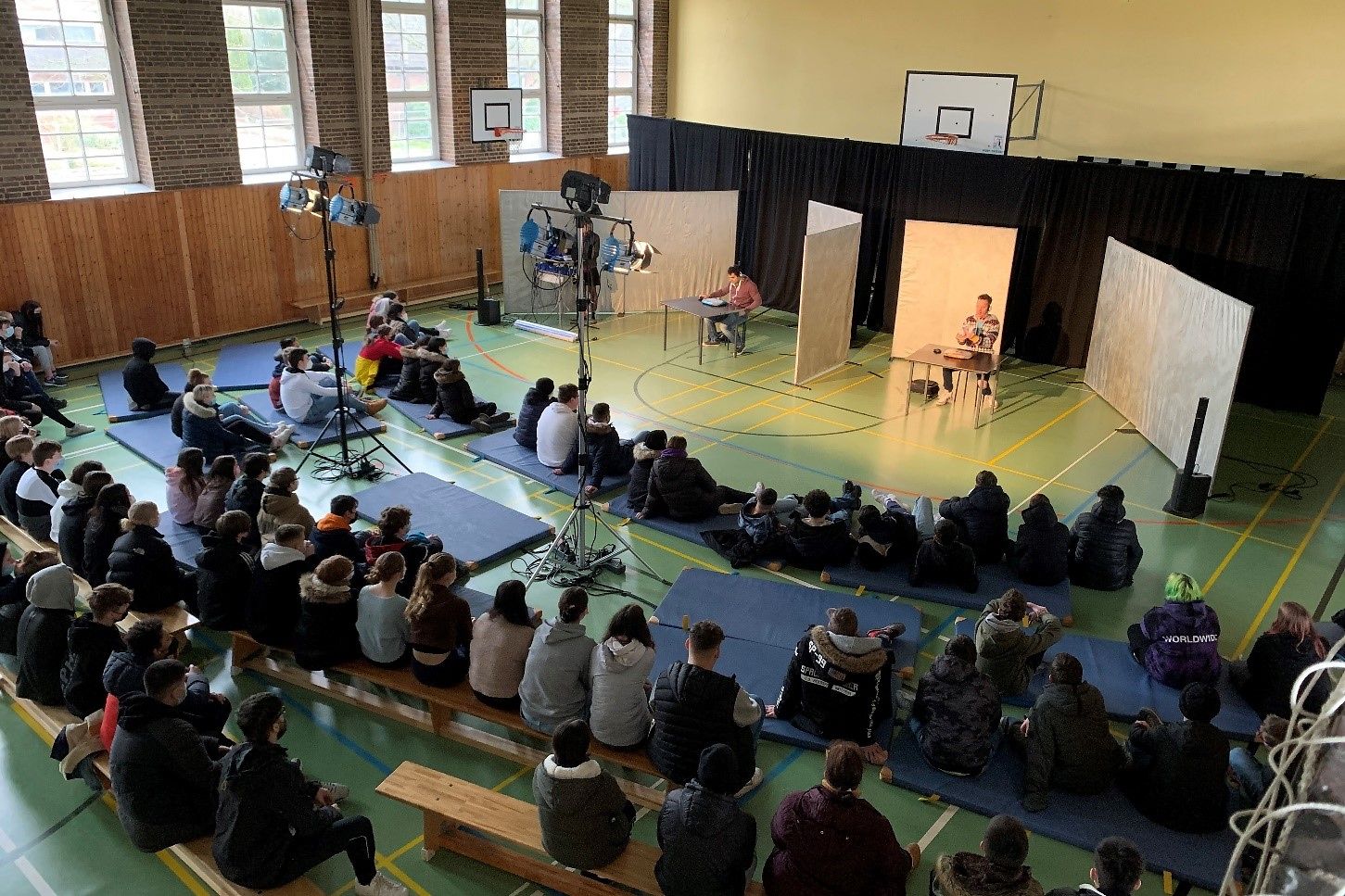 in einer Turnhalle wird vor Puplikum ein Theaterstück vorgeführt