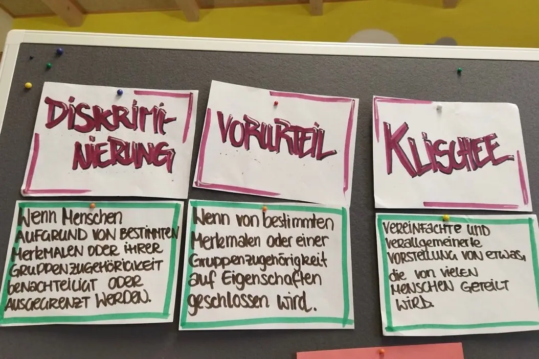 Vier Zettel mit einem Text auf einer Pinnwand