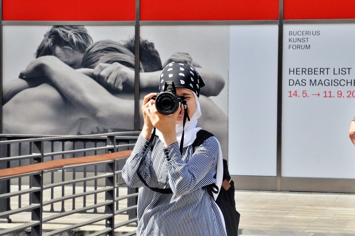 Das Foto zeigt eine fotografierende junge Frau