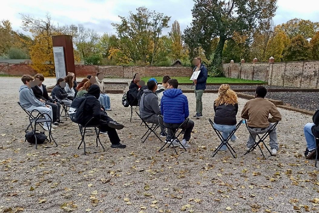 Gruppe Schüler*innen im Gedankenaustausch über die Gedenkstätte.