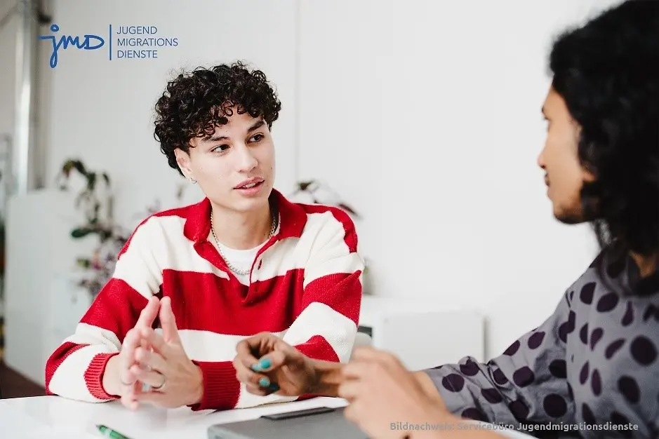 Zwei junge menschen sitzen an einem Tisch.
