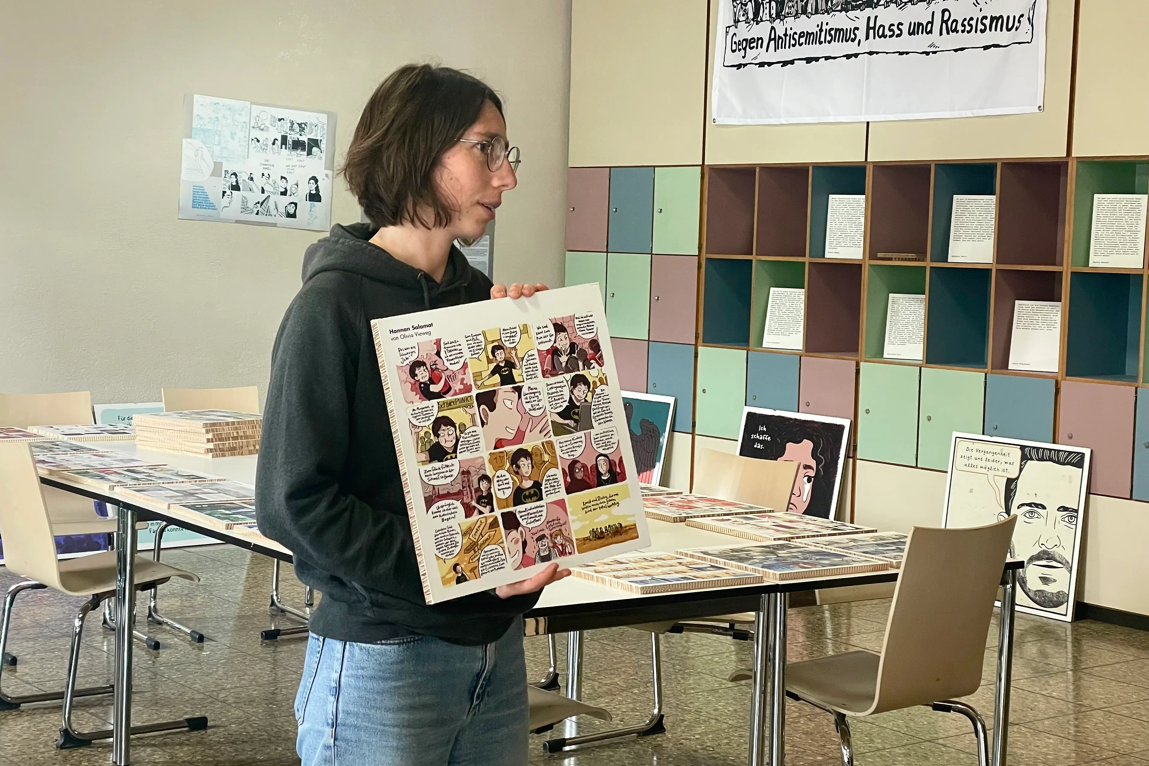 Eine Frau hält ein Bild mit einem Comic drauf.