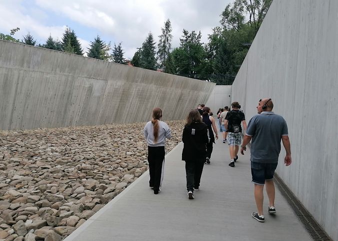 Eine Gruppe con Jugendlichen im Eingangsbereich des ehemaligen Vernichtungslagers Auschwitz-Birkenau.