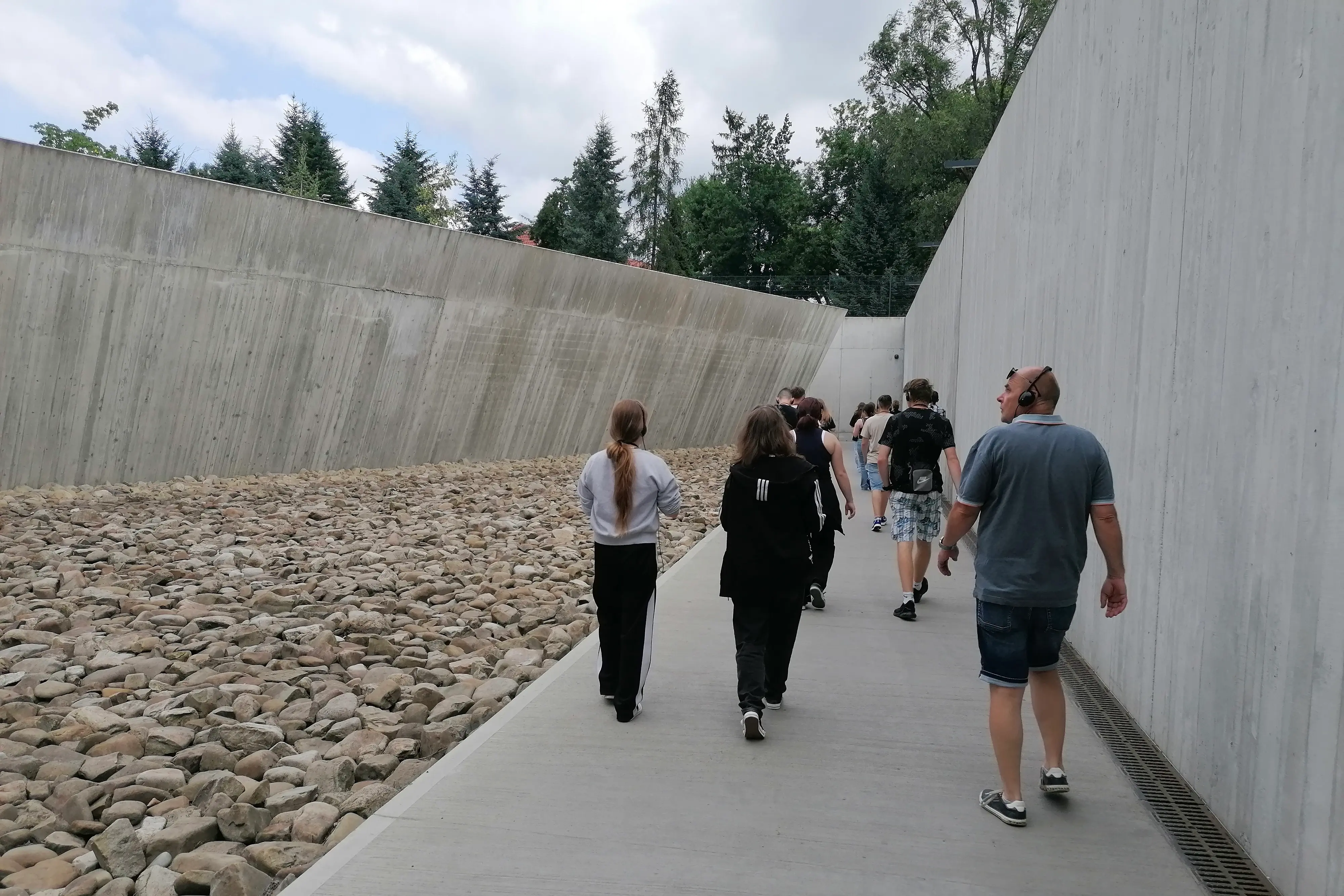 Eine Gruppe con Jugendlichen im Eingangsbereich des ehemaligen Vernichtungslagers Auschwitz-Birkenau.