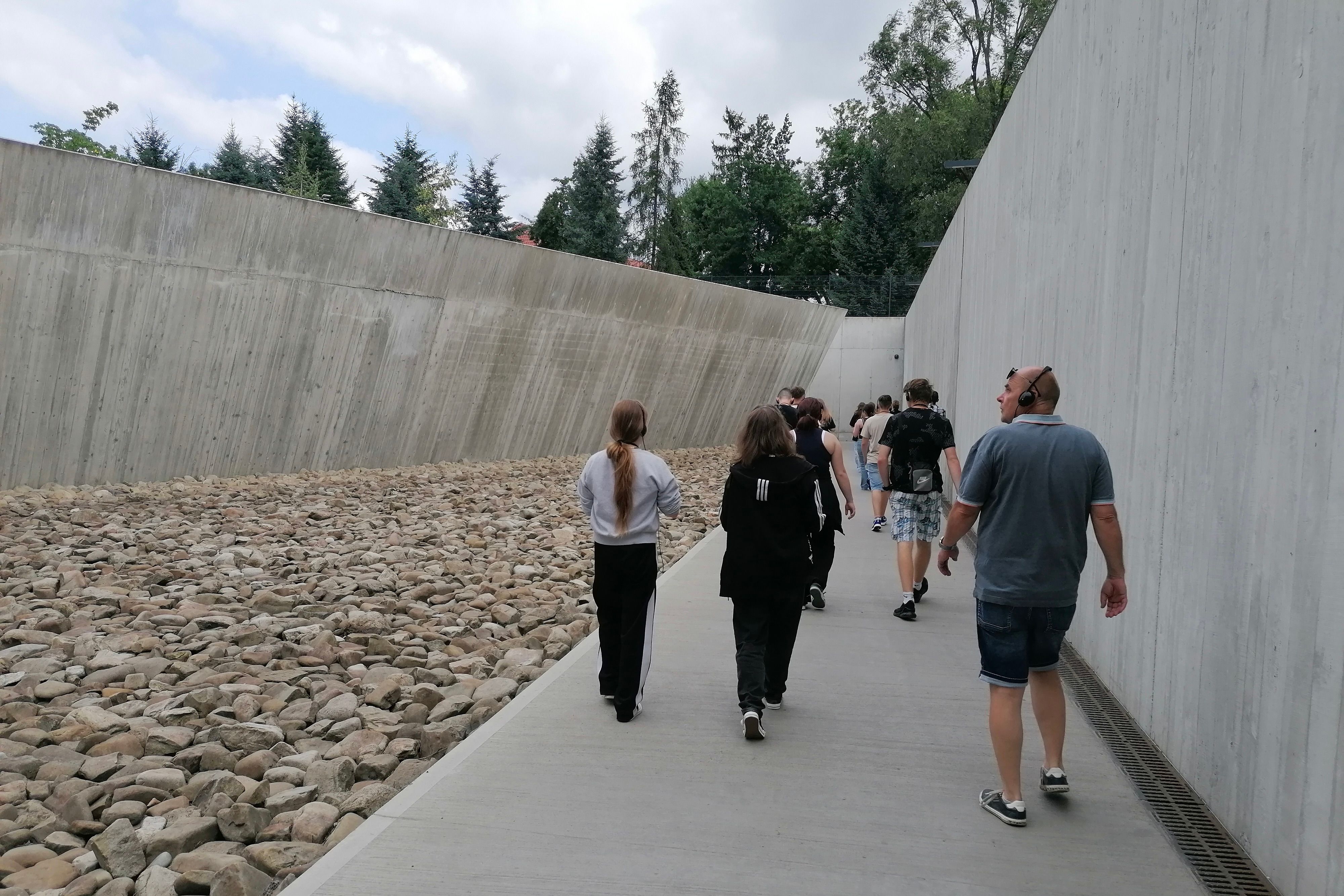 Eine Gruppe con Jugendlichen im Eingangsbereich des ehemaligen Vernichtungslagers Auschwitz-Birkenau.