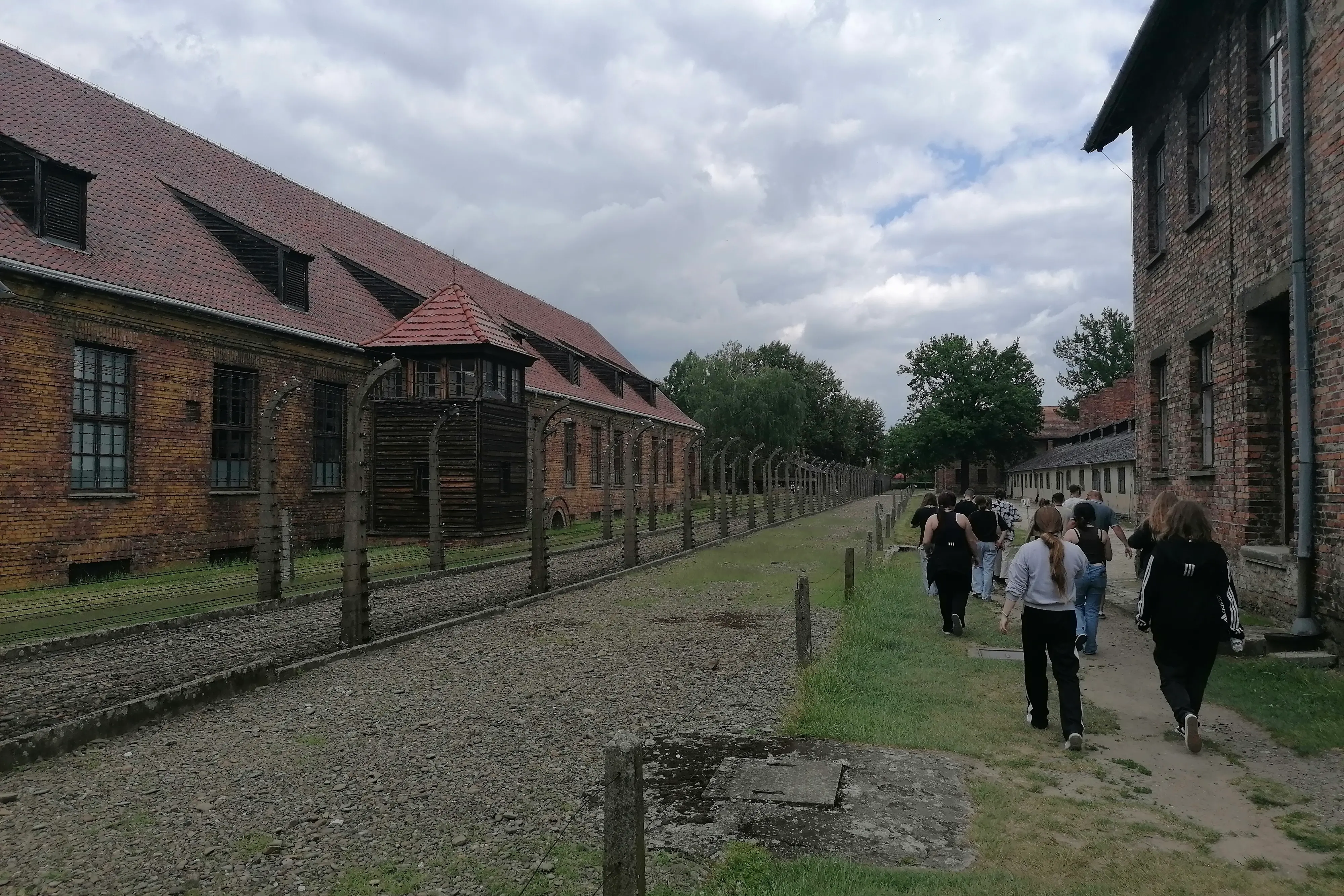 Eine Gruppe von Jugendlichen geht durch das Stammlager Auschwitz I.