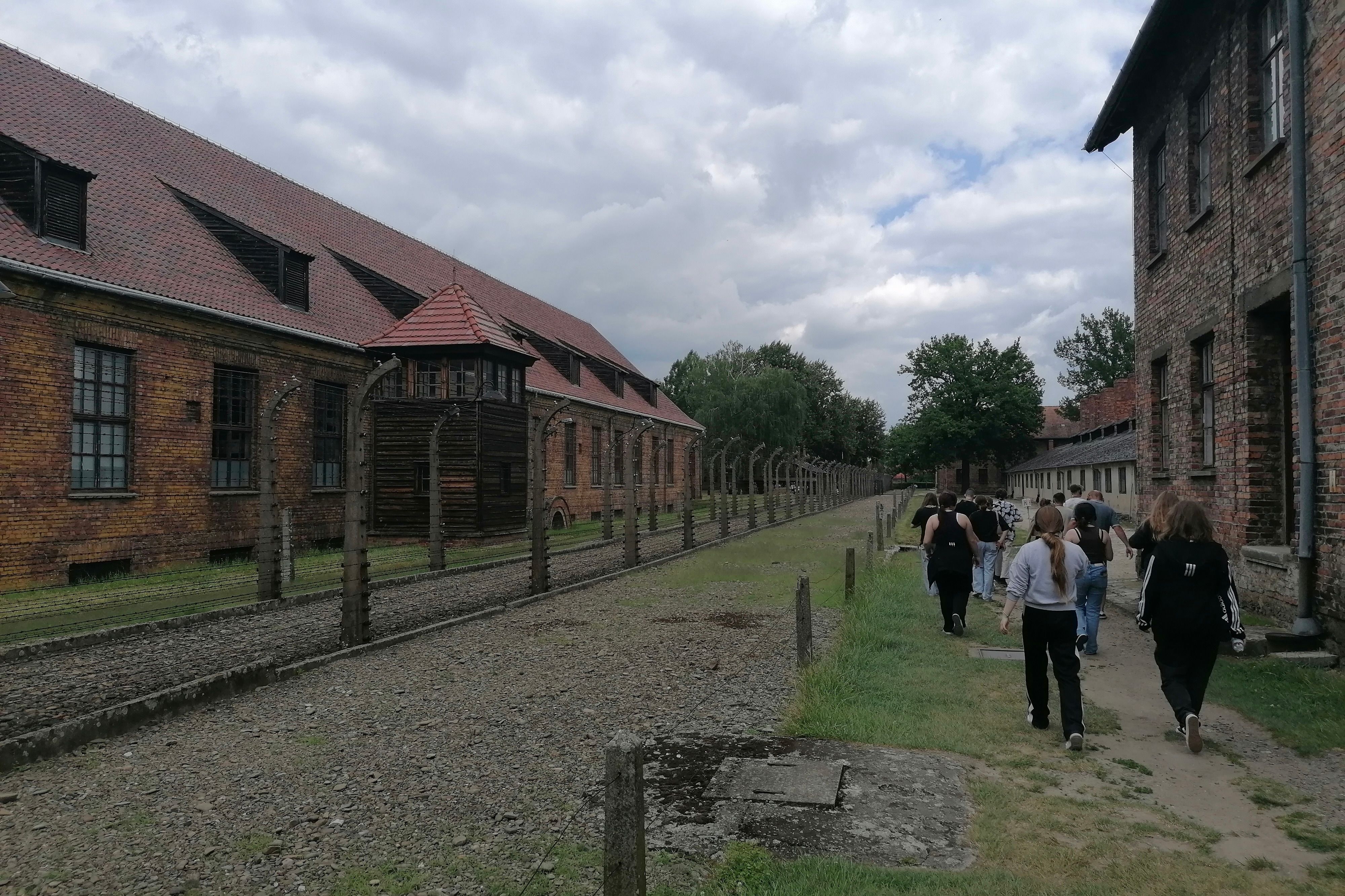 Eine Gruppe von Jugendlichen geht durch das Stammlager Auschwitz I.