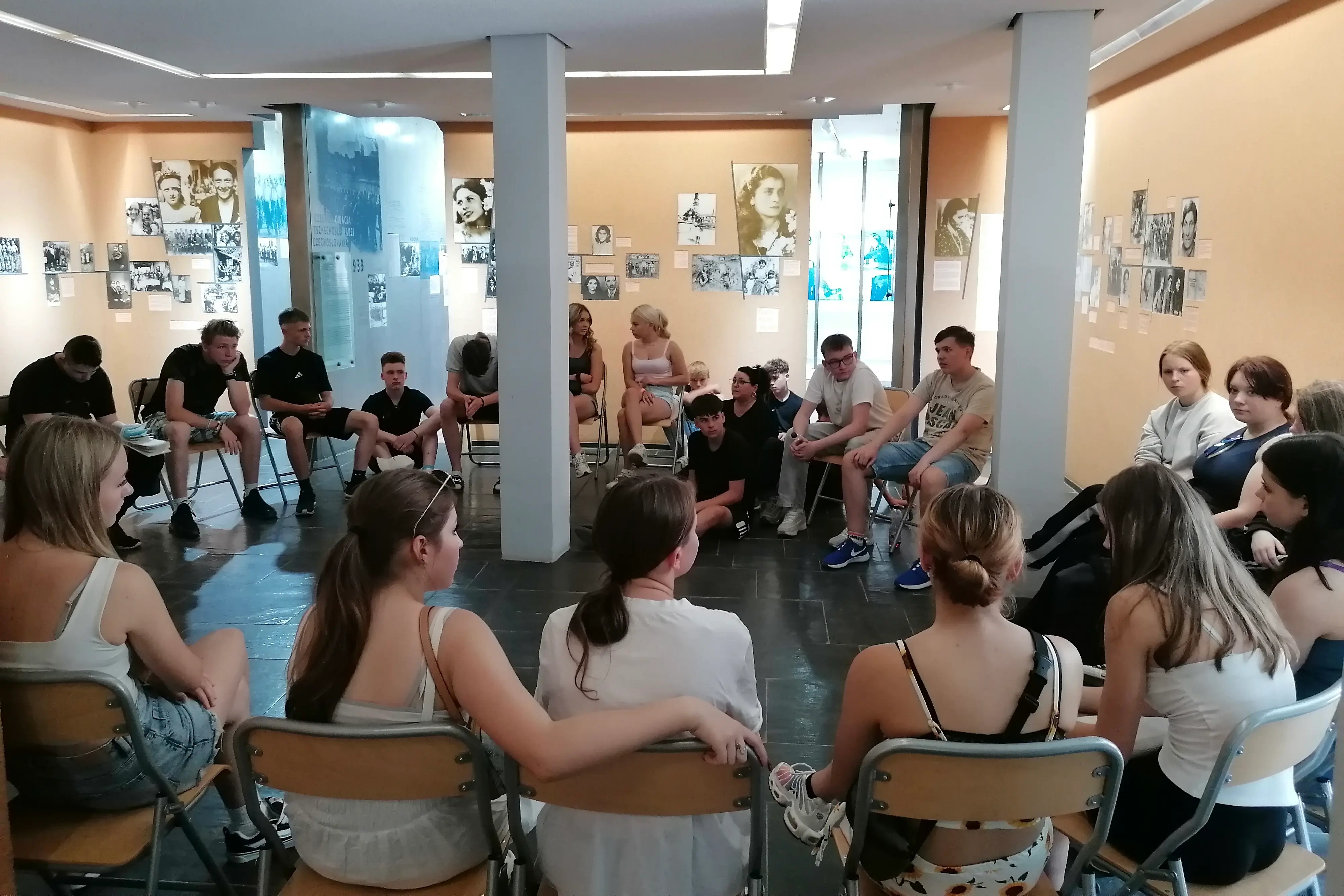 Eine Gruppe von Jugendlichen sitzt in einem Raum im Kreis.