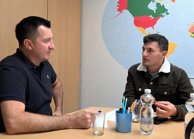 Zwei Männer sitzen an einem Tisch.