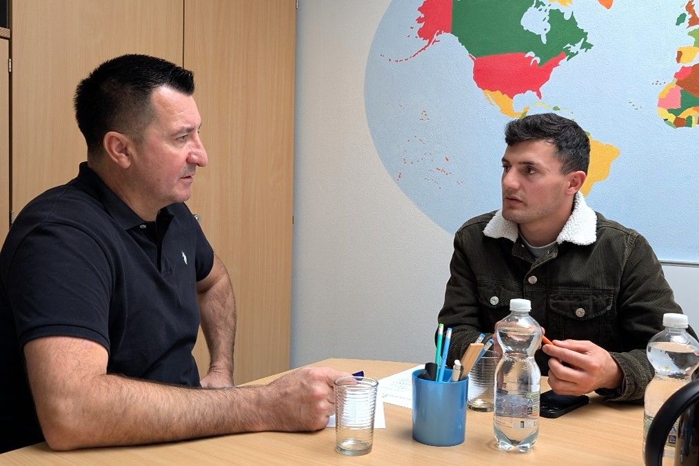 Zwei Männer sitzen an einem Tisch.