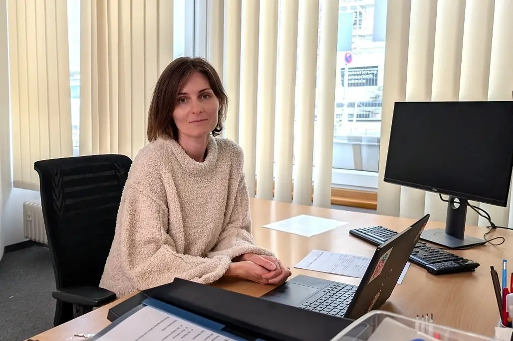 Eine Frau sitzt an einem Schreibtisch.