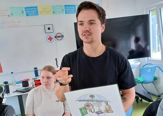 Respekt Coach Marcel Seifert und Studentin Smilla Dahmer sprechen mit der siebten Klasse über Artikel im Grundgesetz.