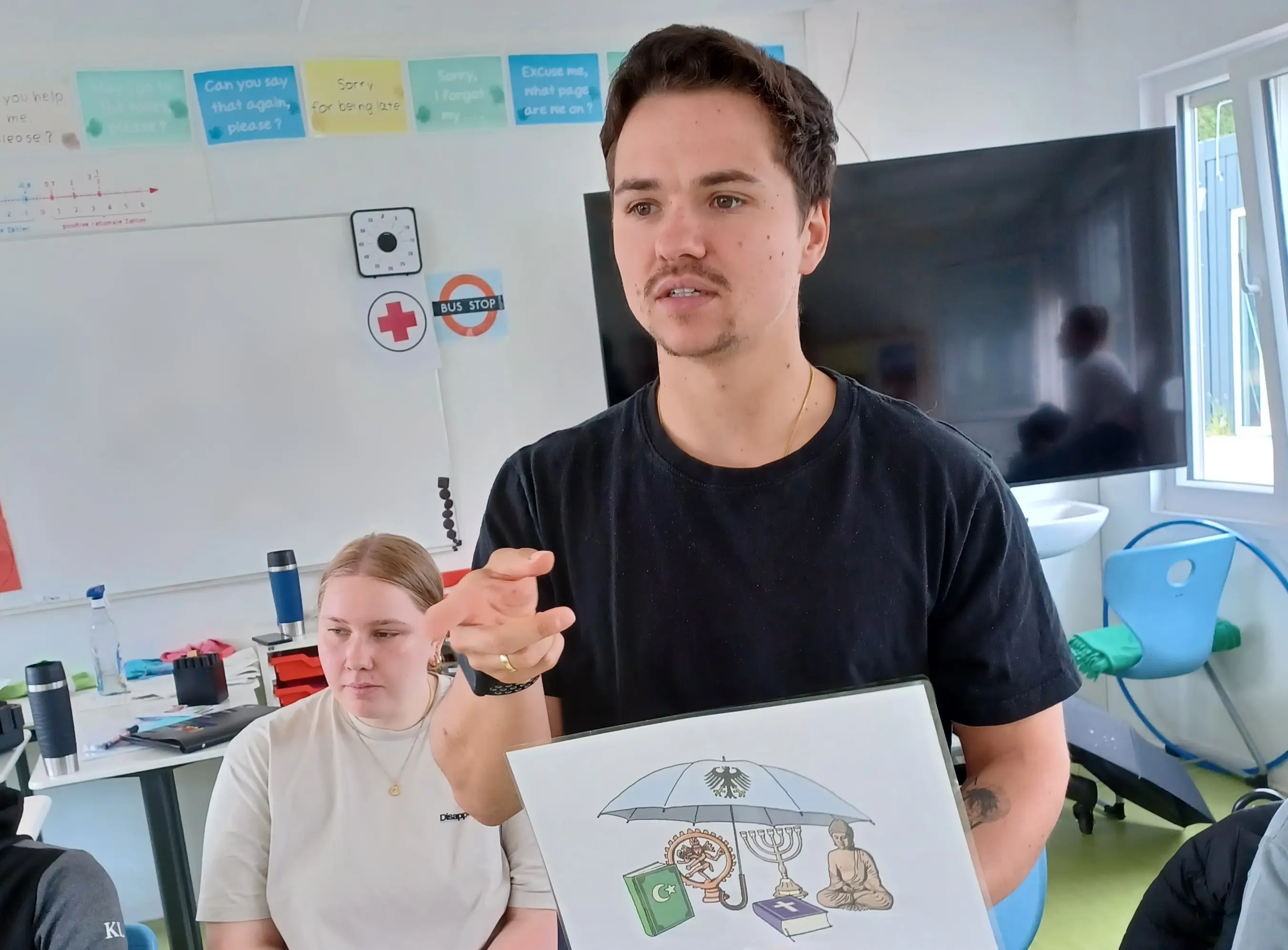 Respekt Coach Marcel Seifert und Studentin Smilla Dahmer sprechen mit der siebten Klasse über Artikel im Grundgesetz.