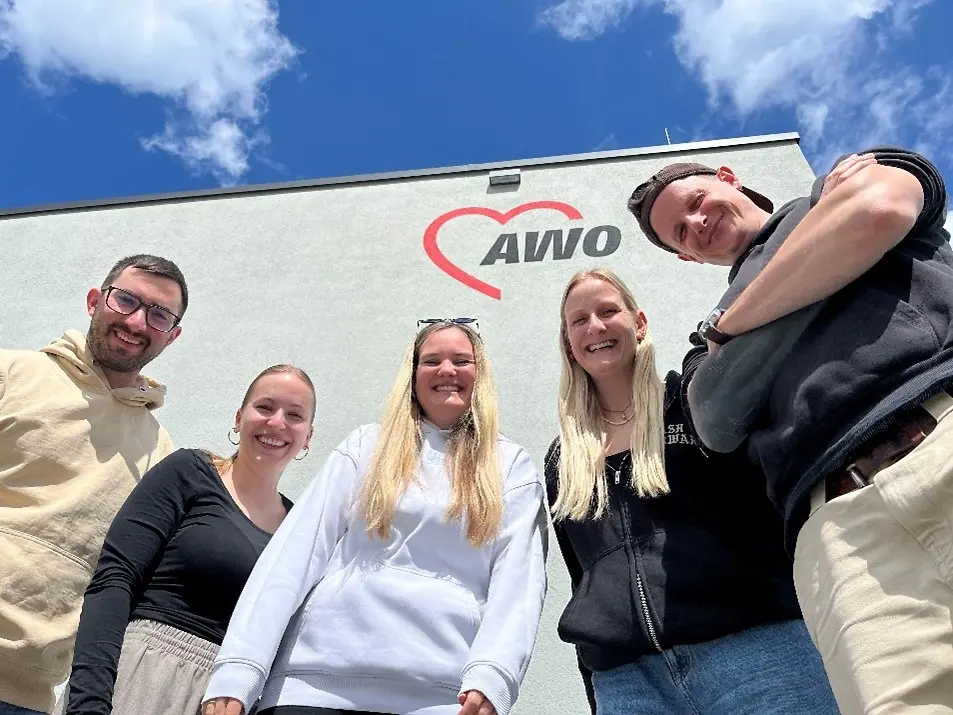 Drei Frauen und zwei Männer stehen vor dem Gebäude der AWO.